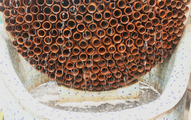Photo of water running over terra-cotta pipes segments