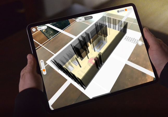 An iPad Pro showing extruded walls in 3D over a CAD drawing.