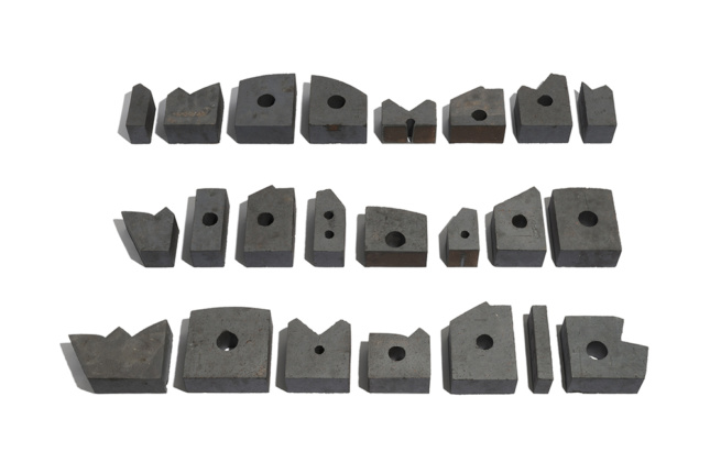 Photo of a layout of differently shaped bricks with holes in the center used in Bureau de Change's interlock project.