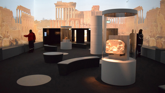 Installation view of some archeological fragments and large projections on gallery walls