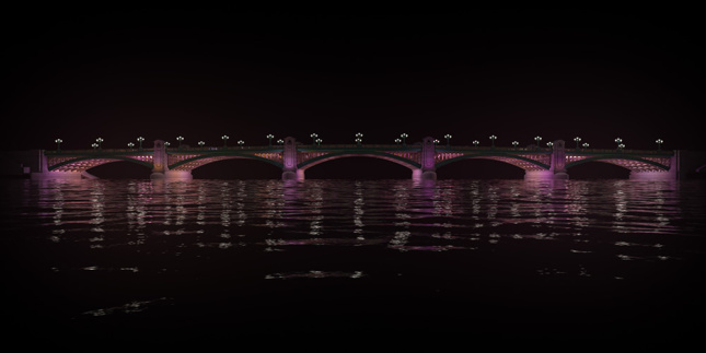 Side view of a lit-up bridge.
