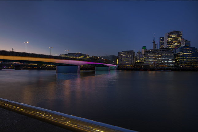 Oblique view of London Bridge with colorful lighting.