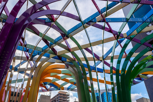 A view through different colored pieces of aluminum interwoven into a canopy.