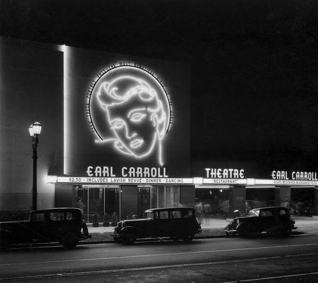 A black and white photo of a theater with the words "Earl Carroll" on top