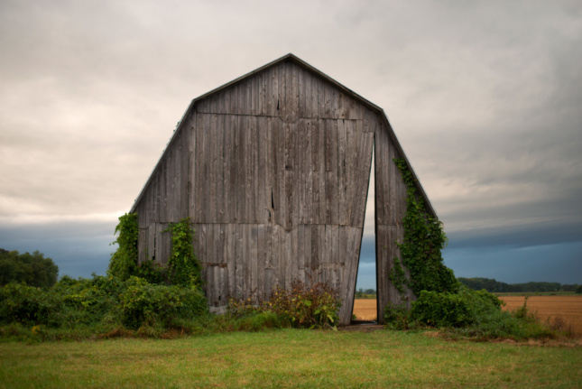 A barn set against a cloud sky in a plain
