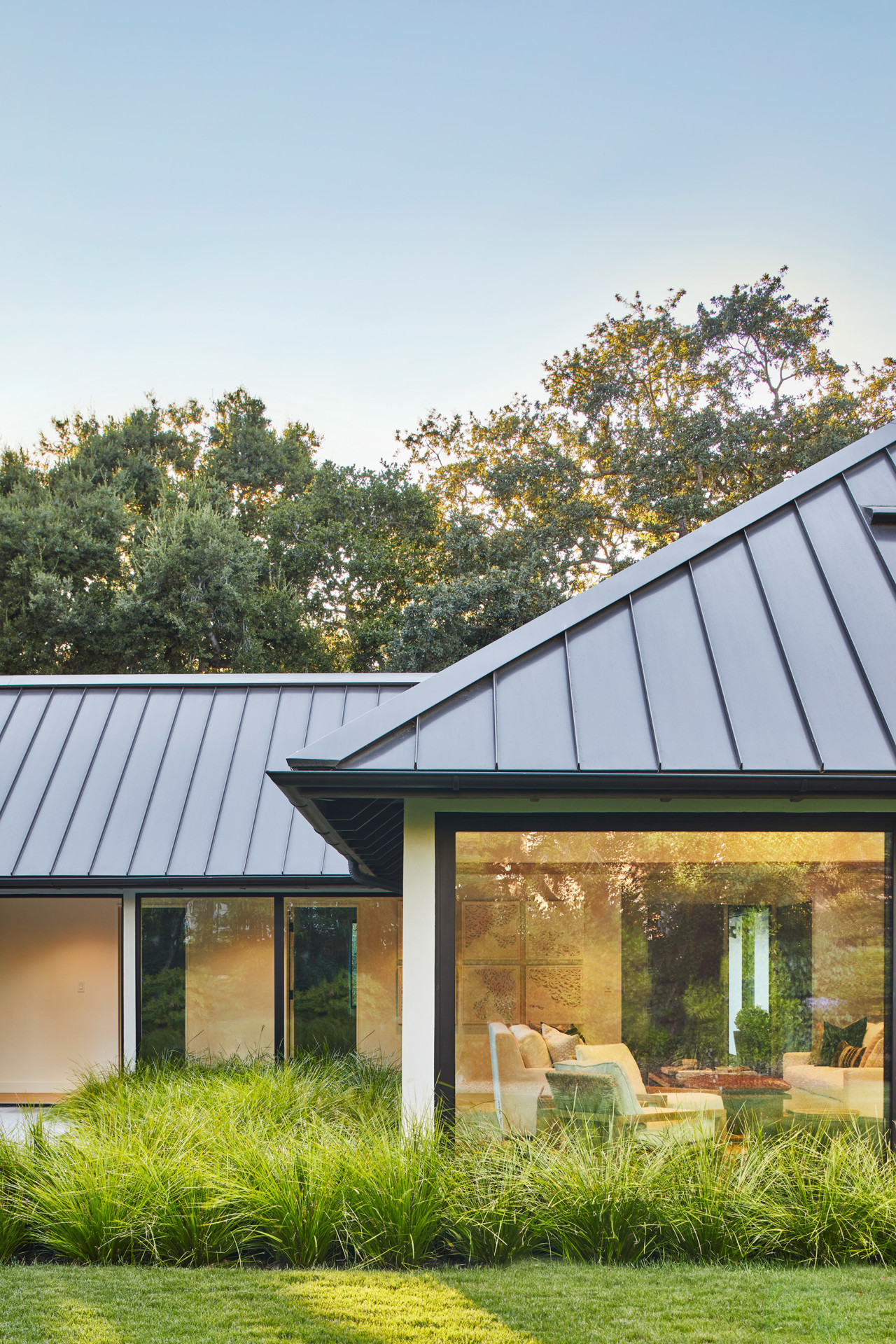 a squat gabled home with zinc-clad roof