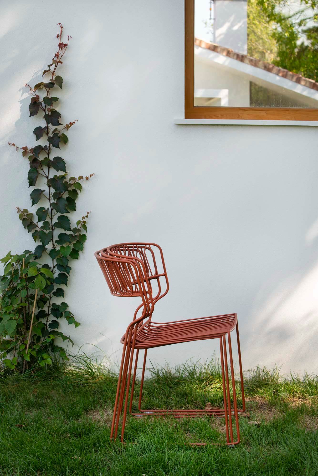 Stacked red outdoor furniture chairs.