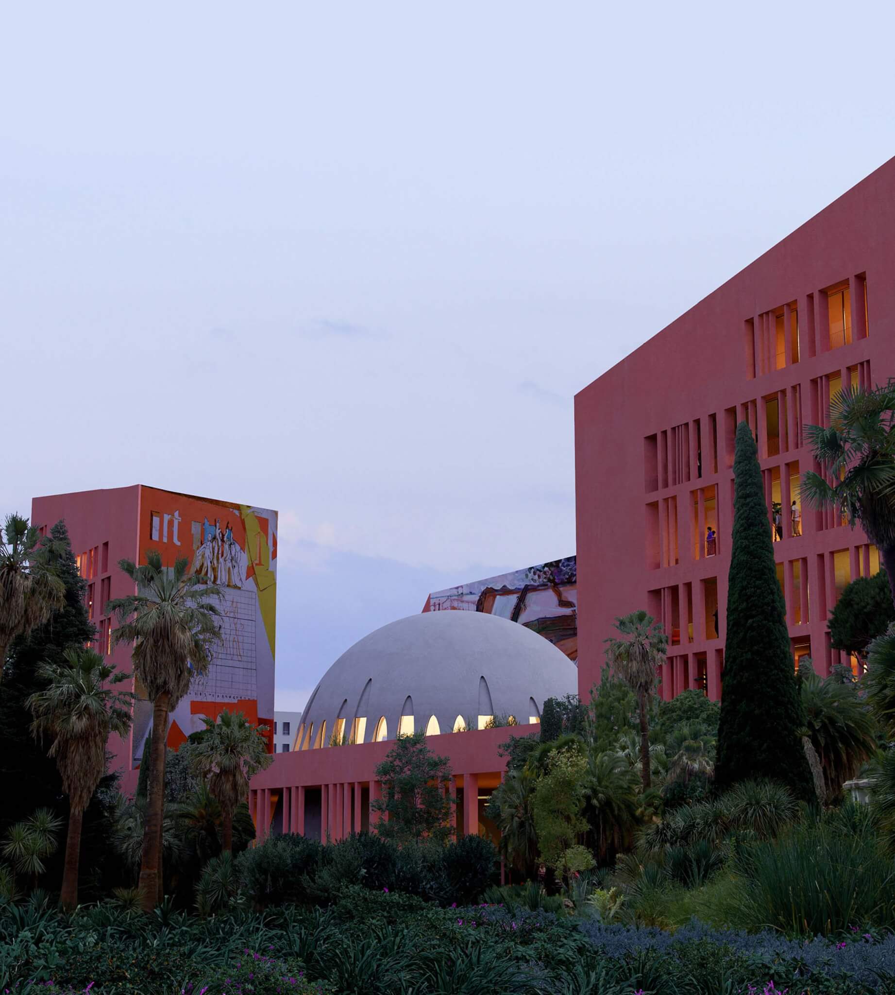 buildings on the campus are red and the roof of the agora is domed and white