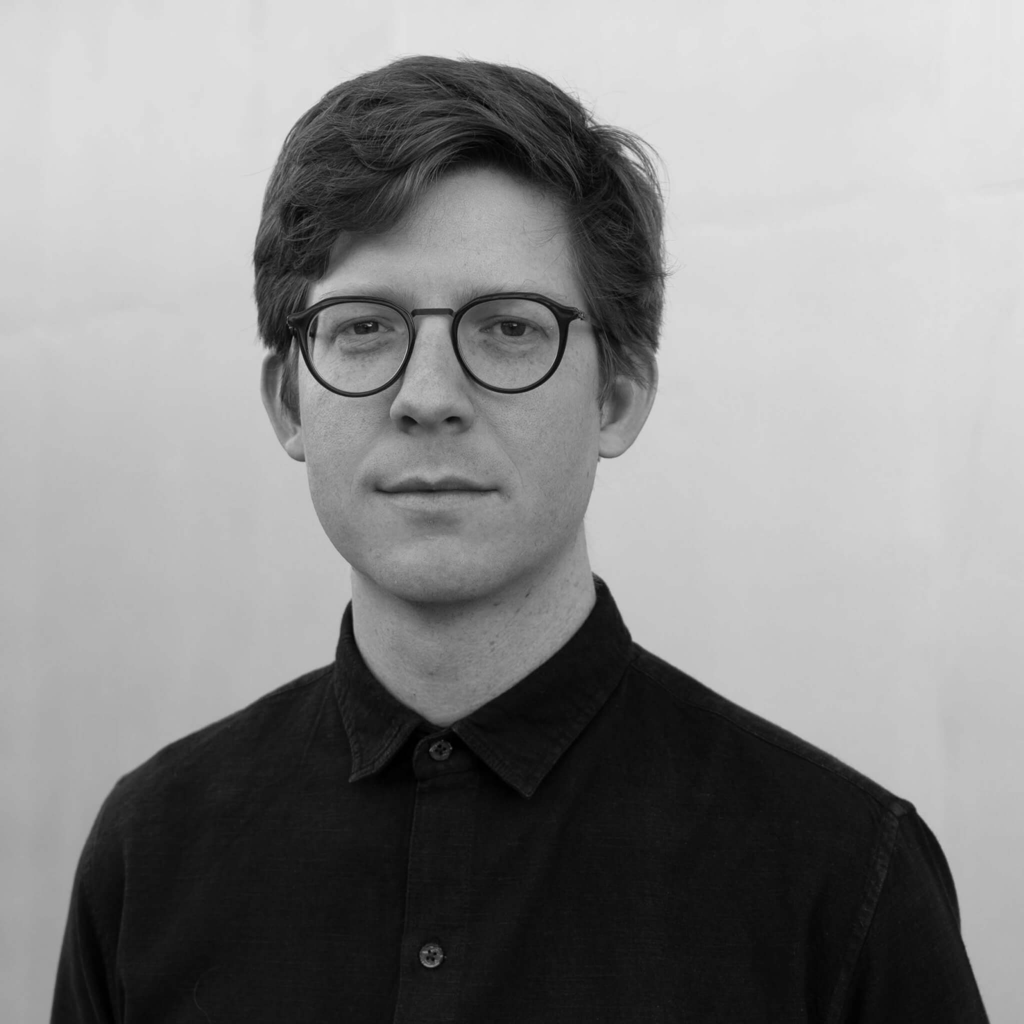 A black and white photo of a man with glasses