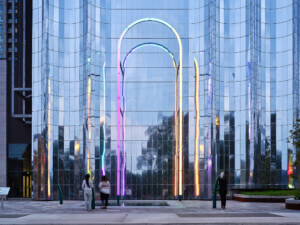 A luminescent arch in front of a mirrored facade.