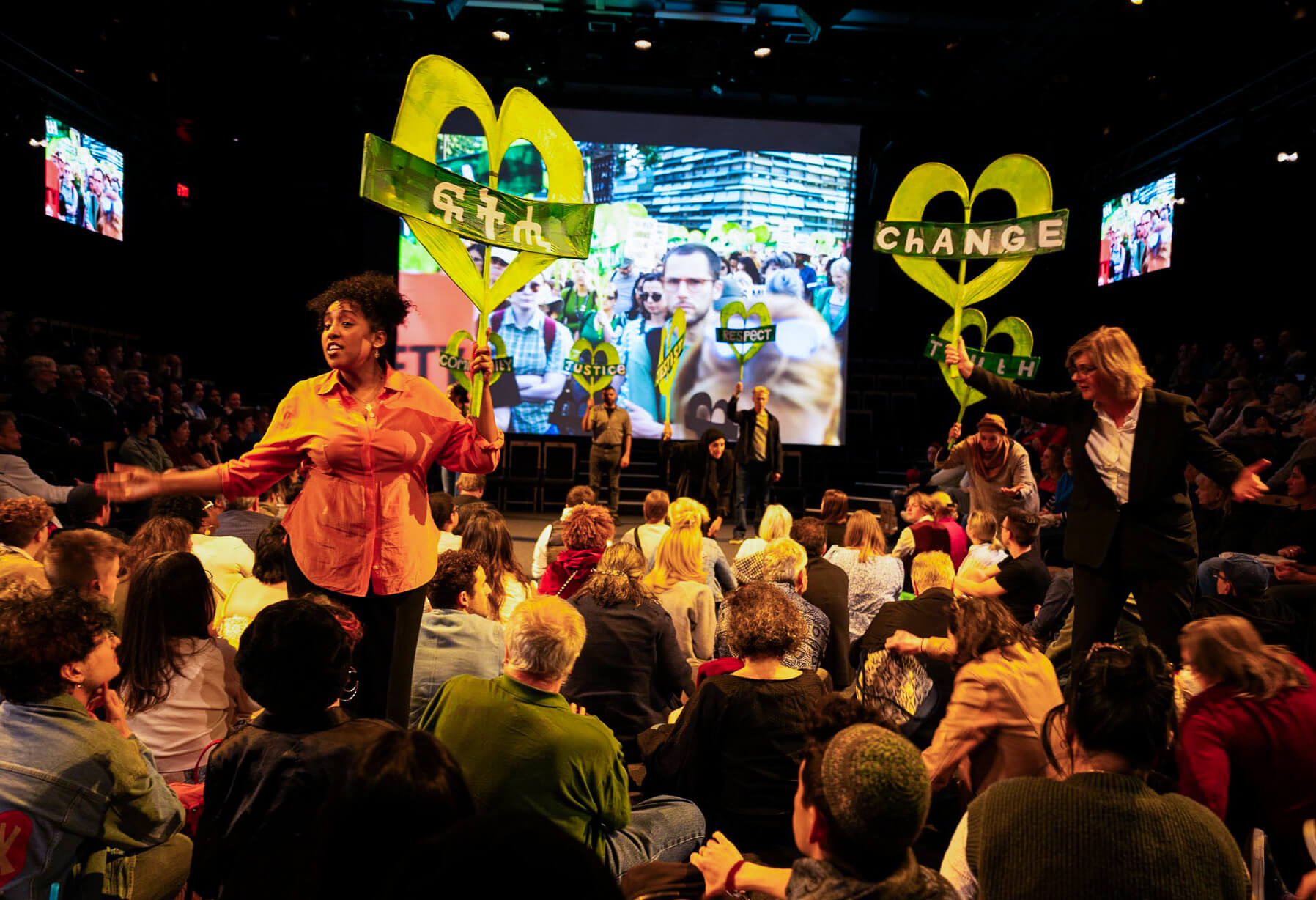 view of stage with performers holding protest signage