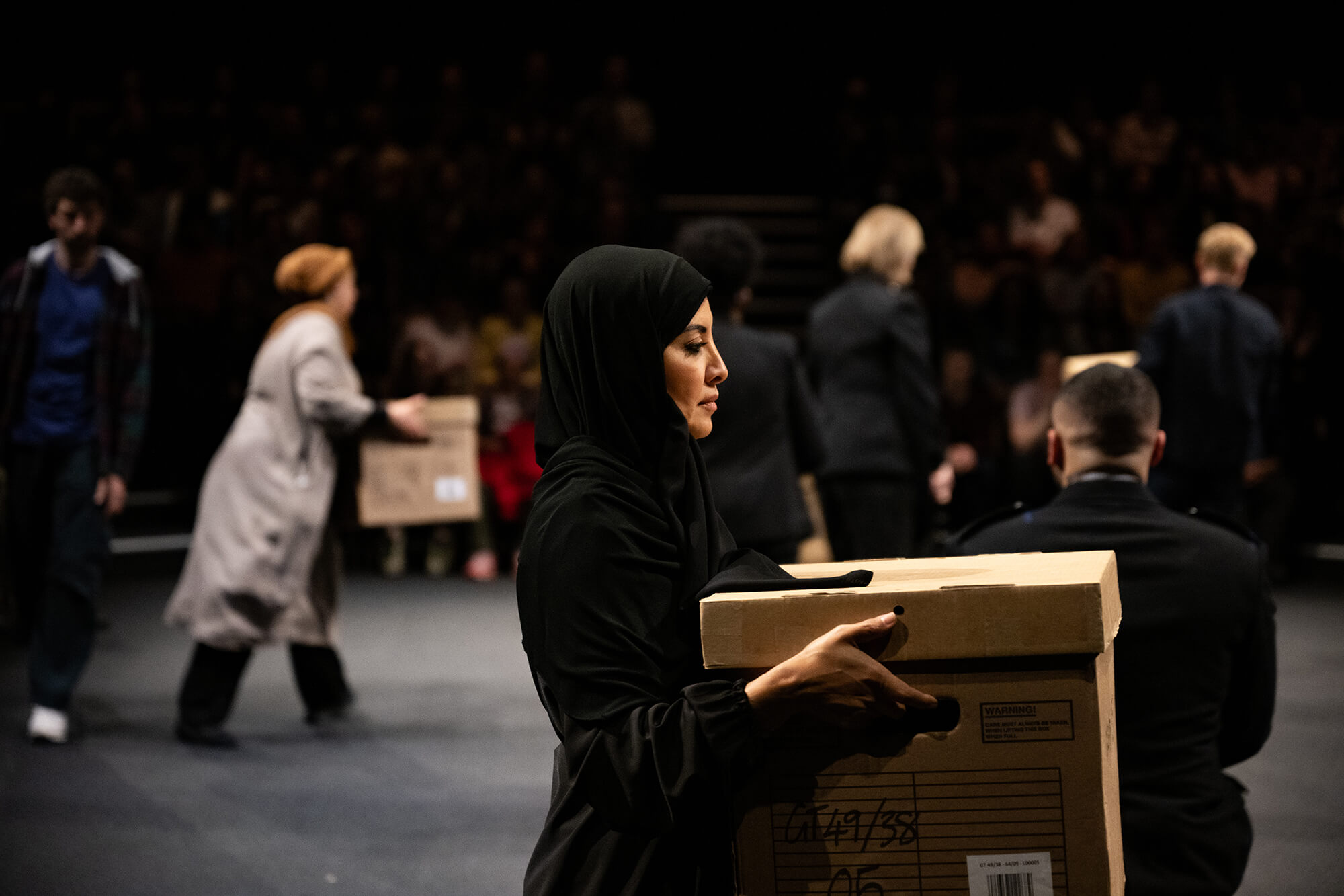 performers hold boxes on stage 