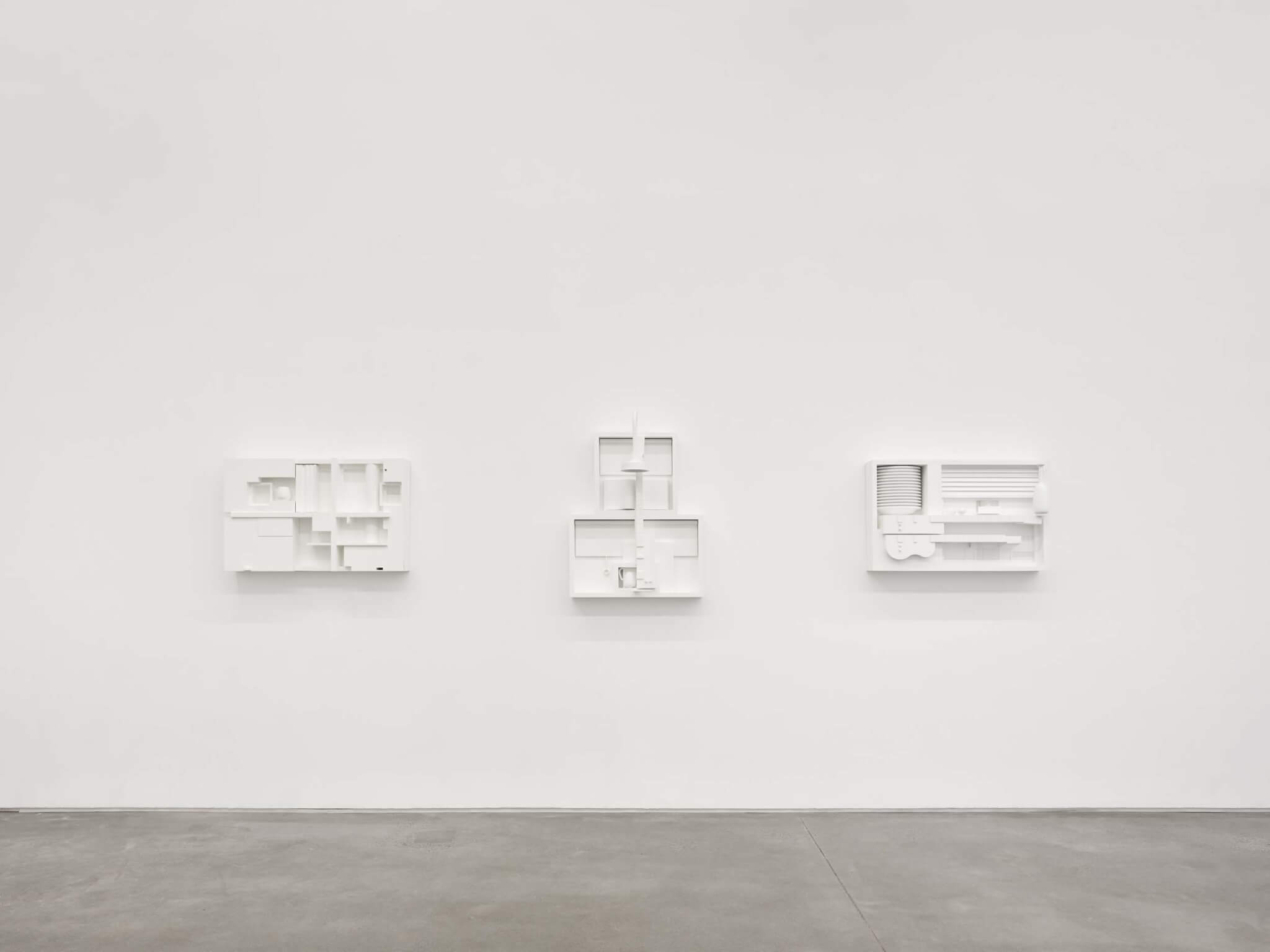 white sculptures hanging on wall