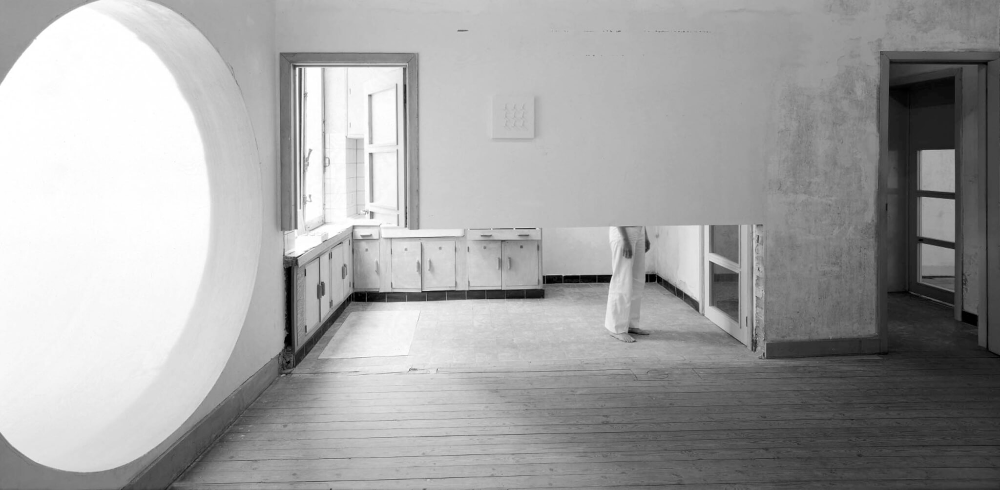 black and white photo of old kitchen and half walls