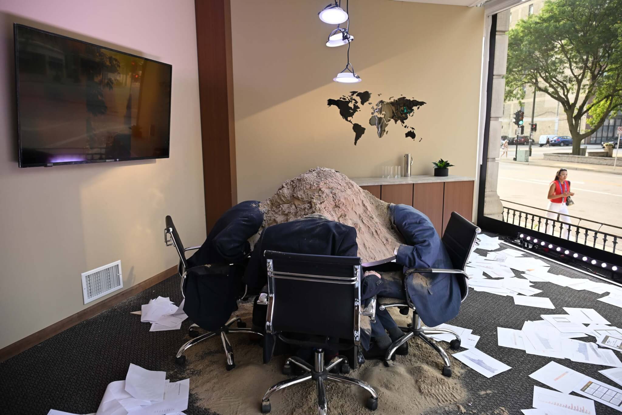 people at conference table with head in the sand