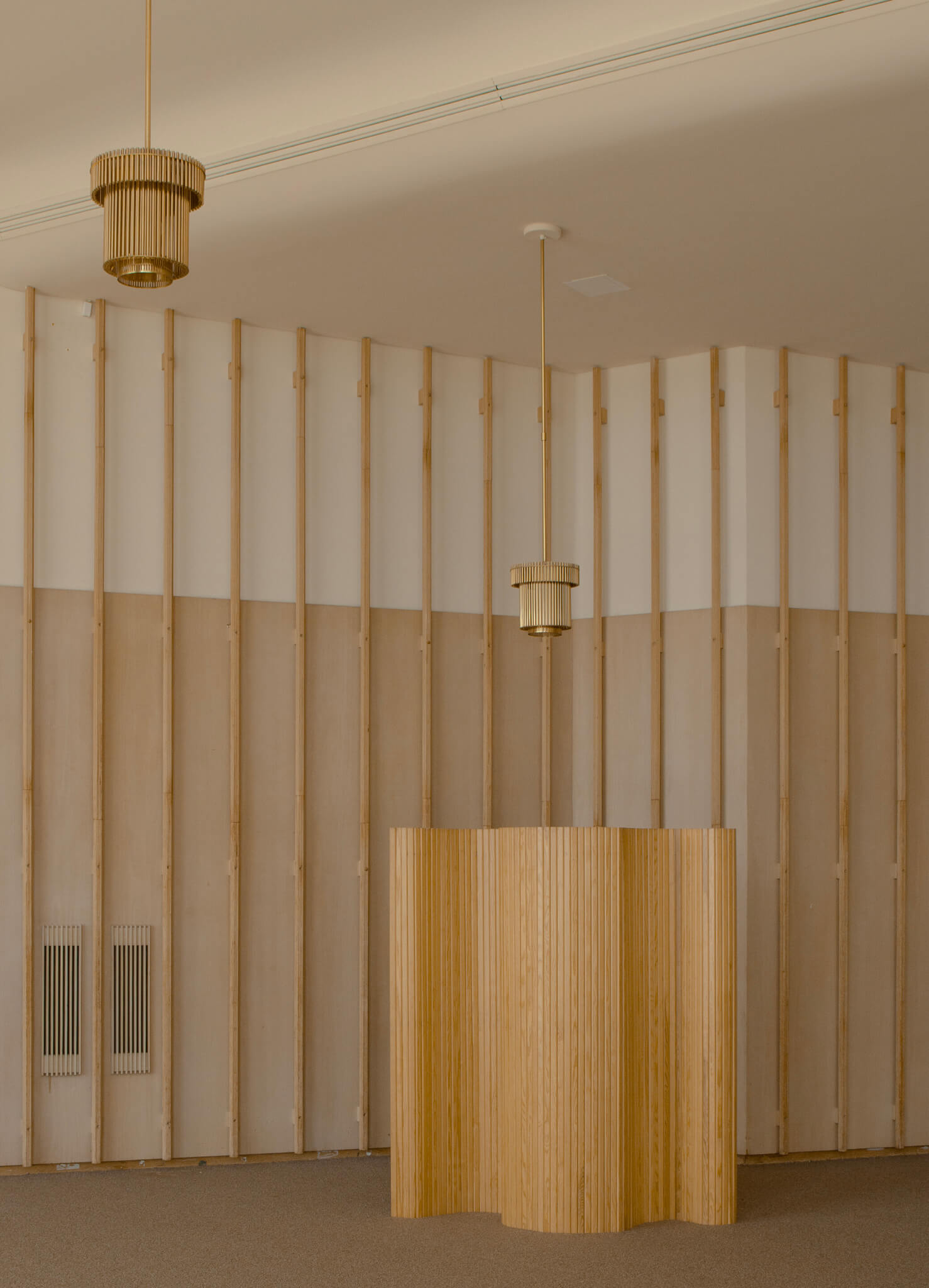 wood paneling and gold light fixtures in room designed by Alvar Aalto