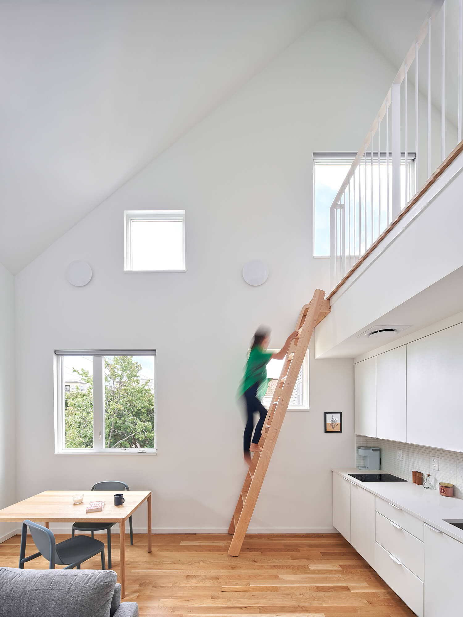 person climbing wooden ladder up to a loft space