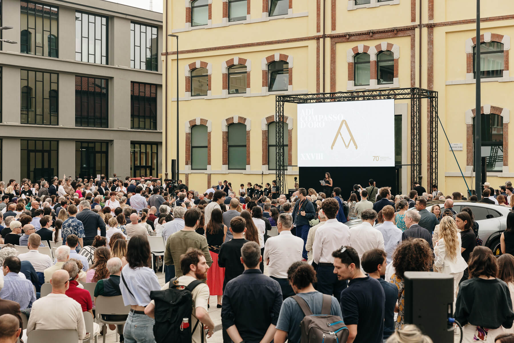 crowd of people gathered at award ceremony outside building in Italy