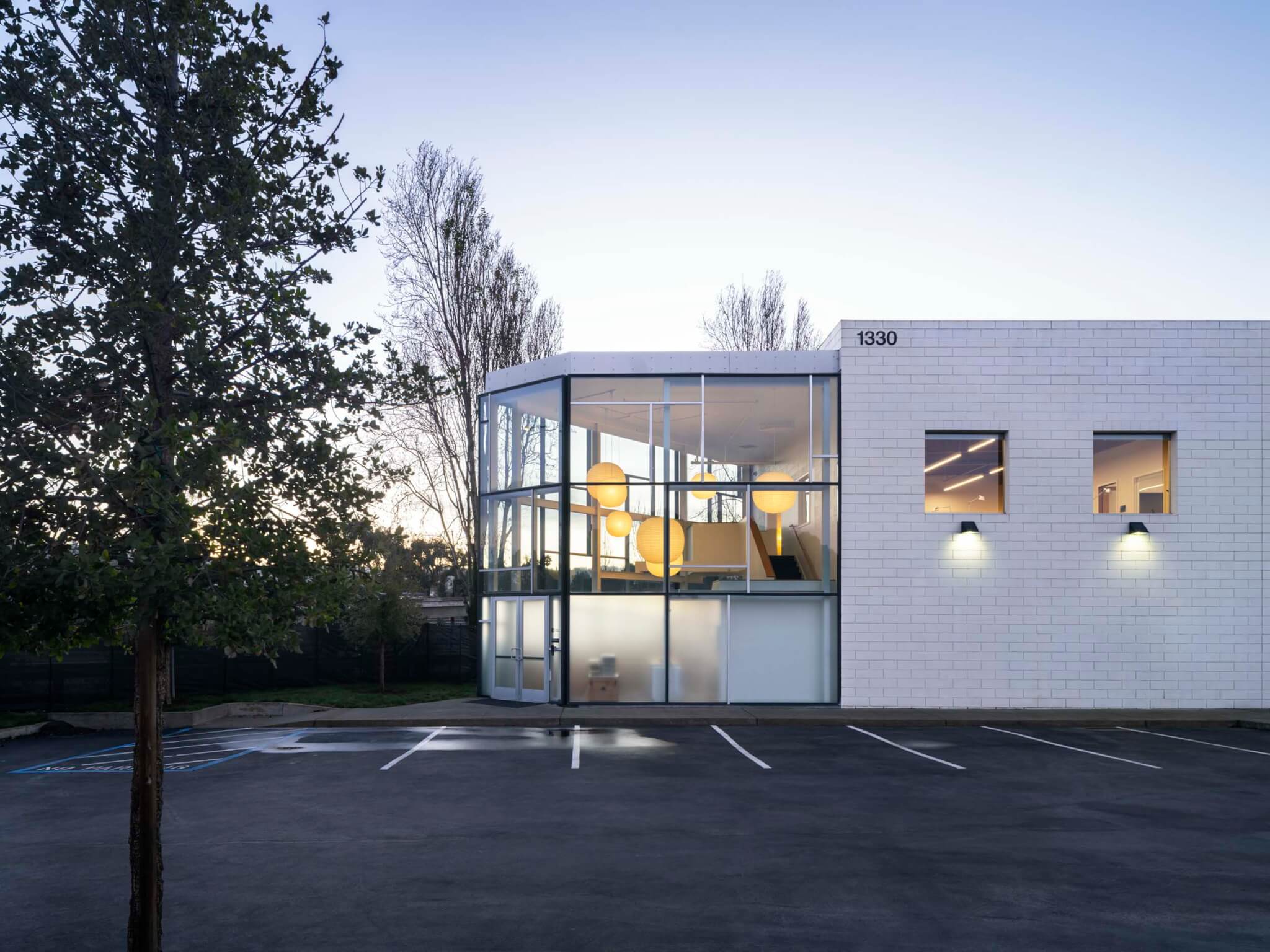 Eames Institute office and archive space in Richmond, California. White brick building with glass panels.