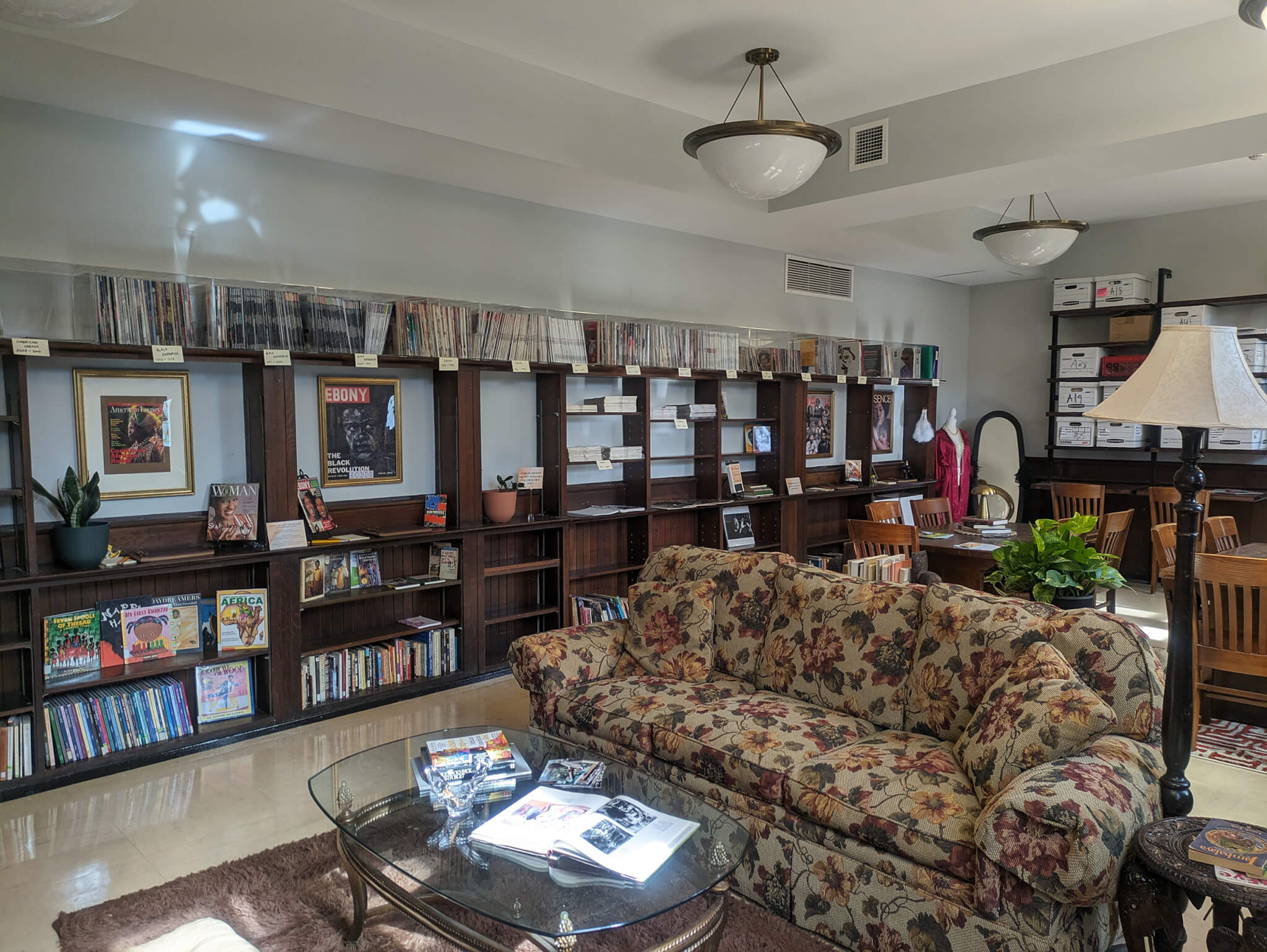 a floral couch surrounded by dark wooden bookshelves