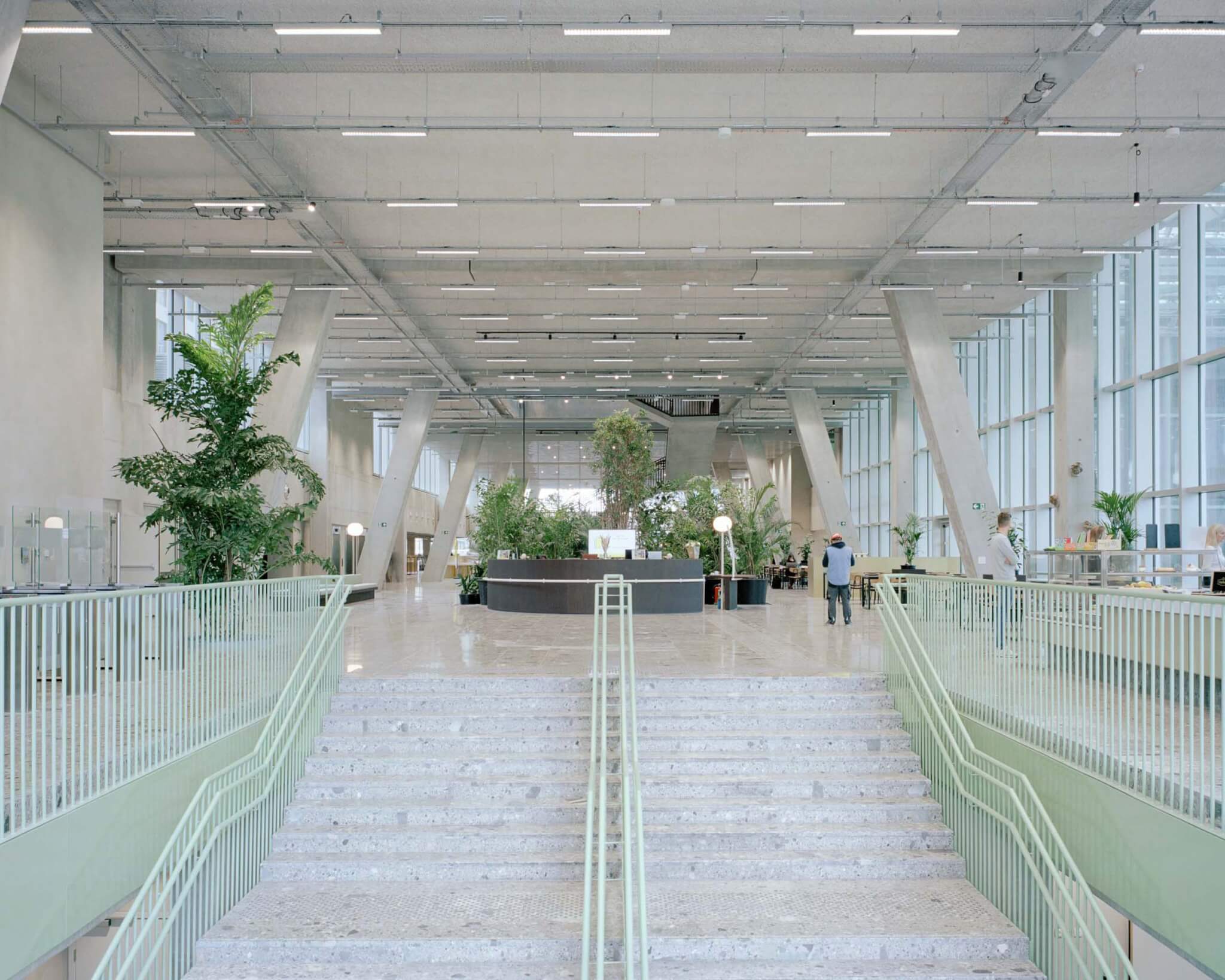 concrete staircase with green railings 