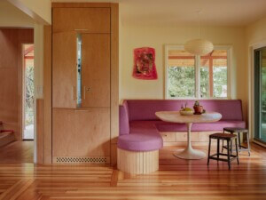 living room with pink sofa and green sofa in a coliving house by Pršić & Pršić