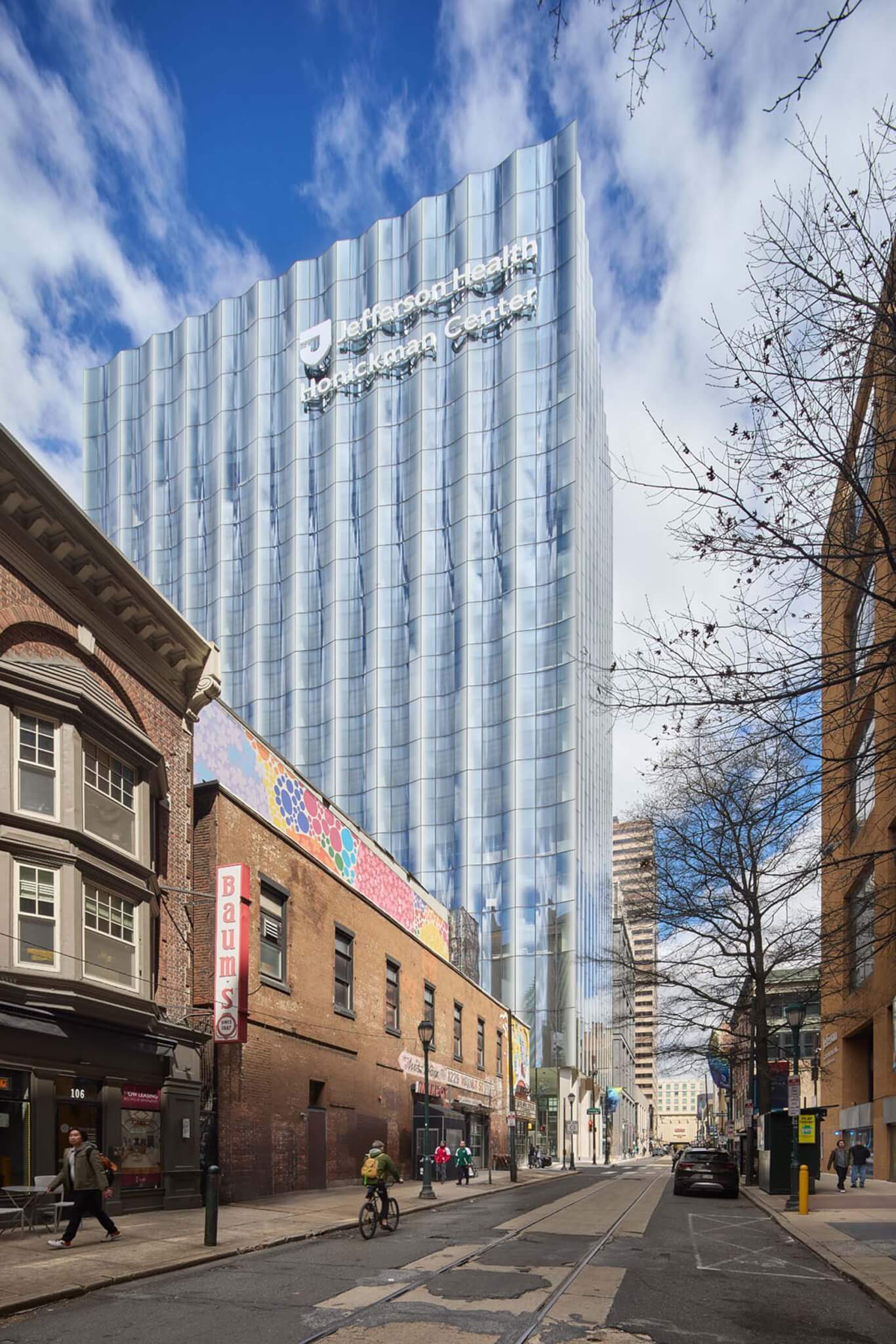 Jefferson Health Honickman Center in Philadelphia by Ennead is a glass tower in a neighborhood with masonry construction 