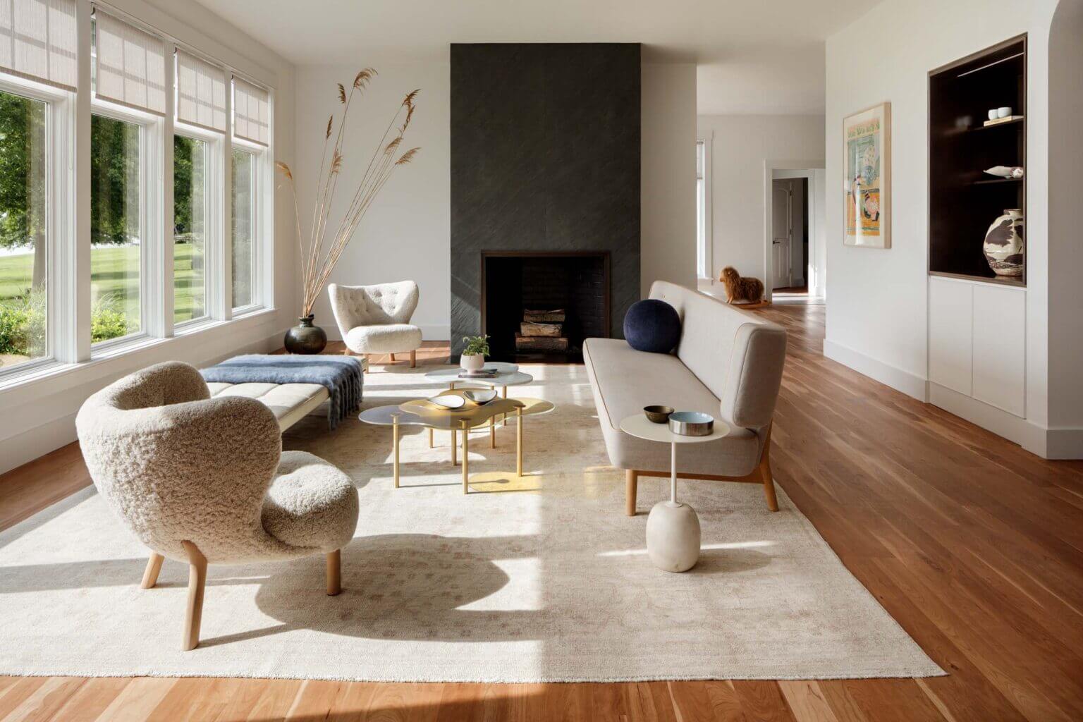 A living room with a black fireplace by Colleen Healey Architecture