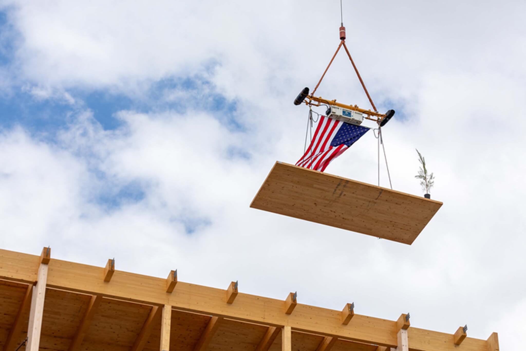 The final wooden piece being added atop building at University of Arkansas