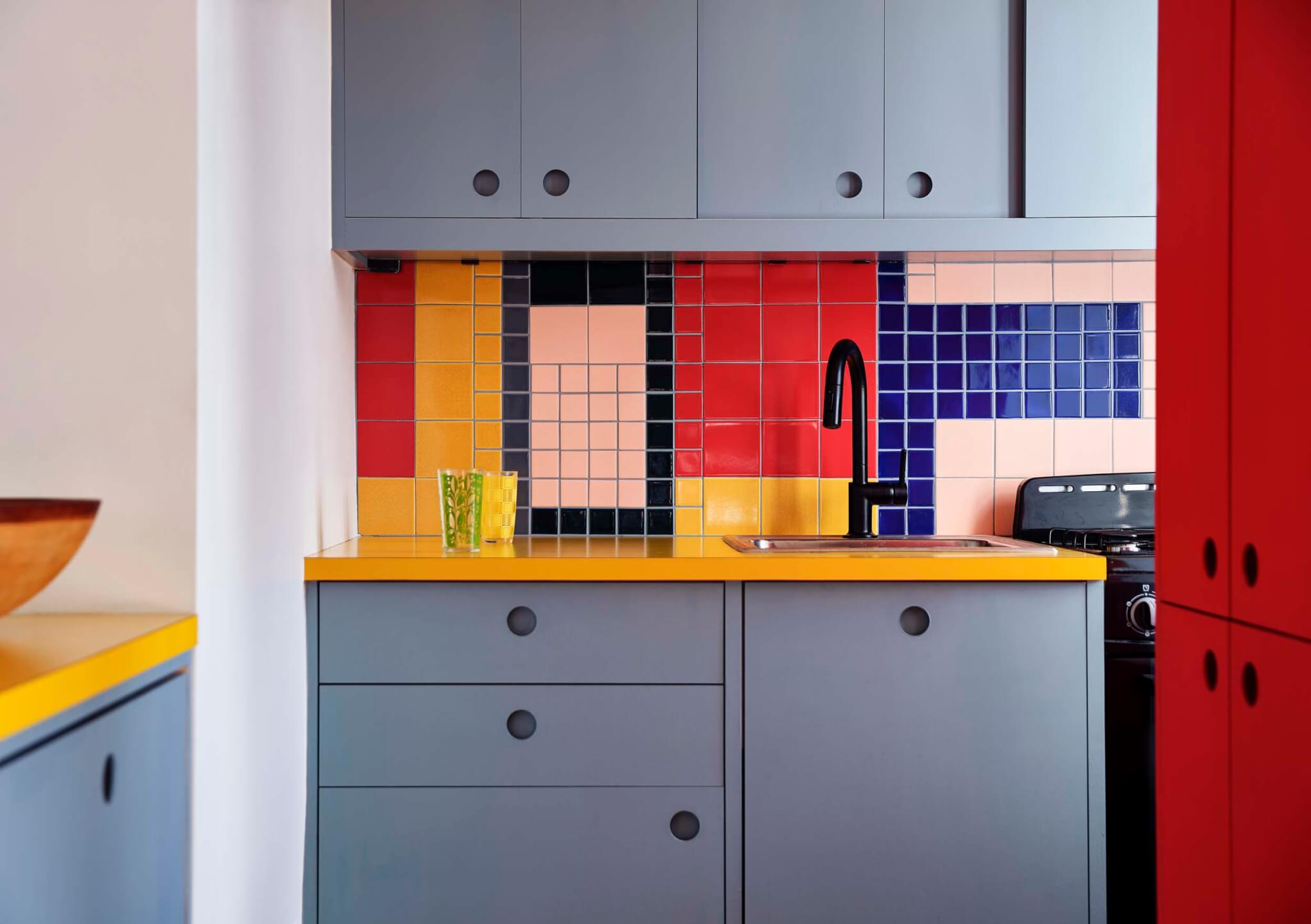 A colorful kitchen with contrasting hues in the backsplash by Sarah Jacoby