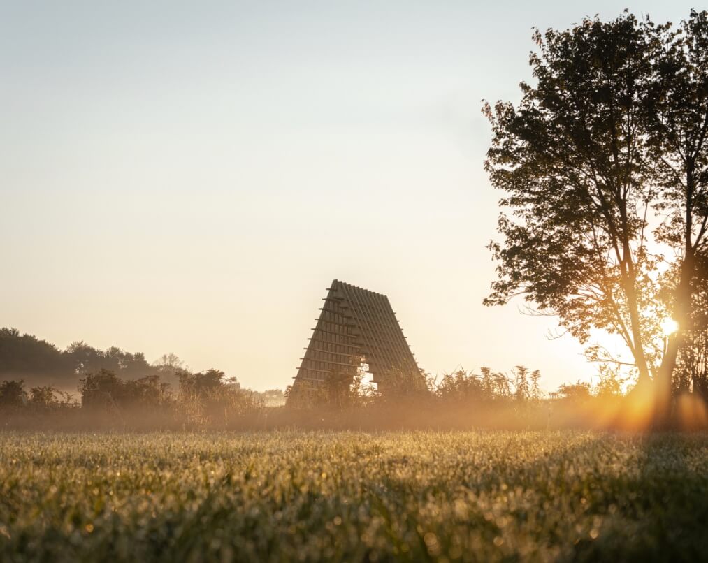 A-framed shaped structure in a field with trees