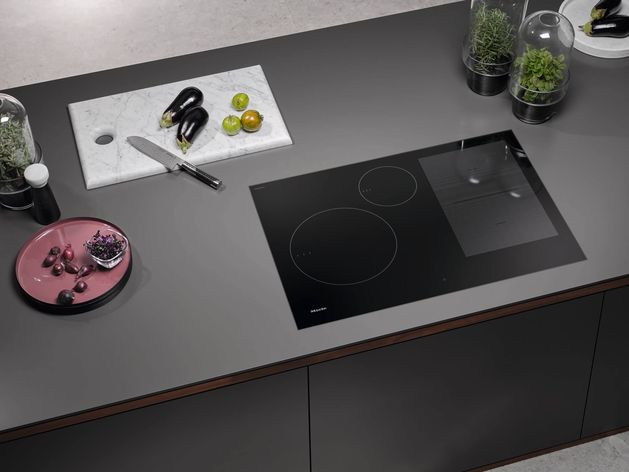 A black, sleek induction cooktop from Miele