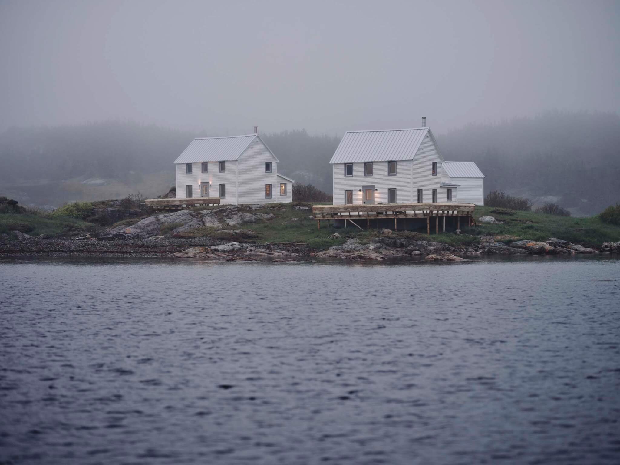 A moody, dark sky covers two coastal homes, Burdens Point residences