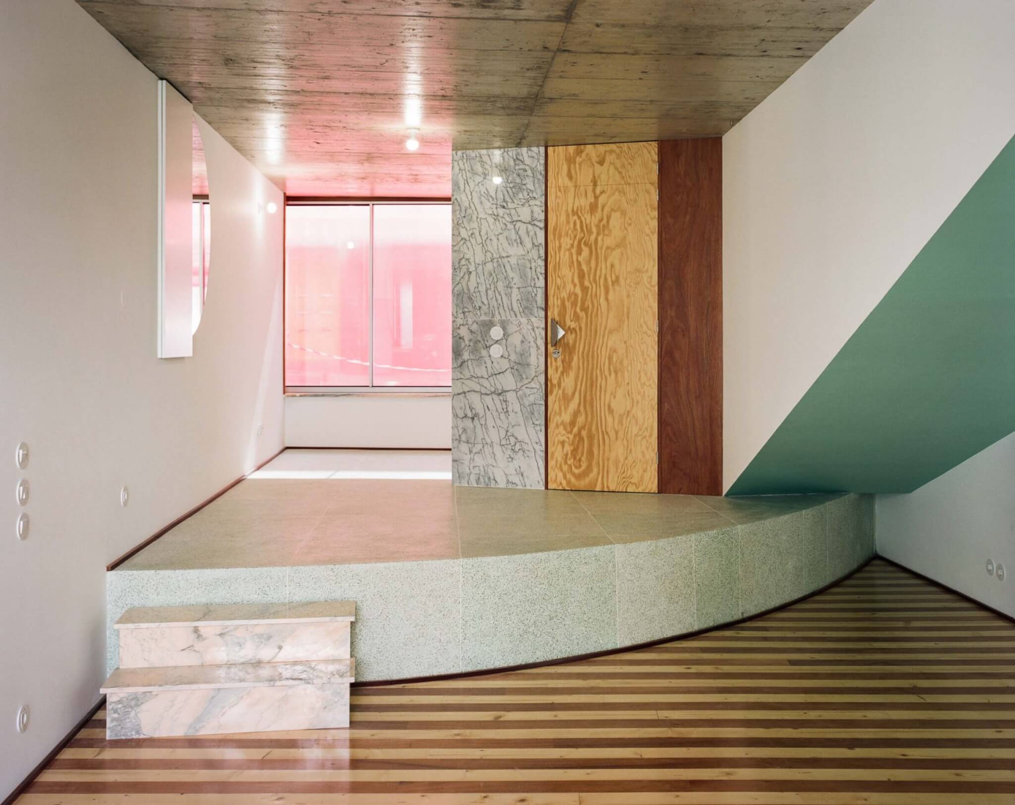 A striped floor of an apartment, 102, features a semi-circular platform and random wall protrusions