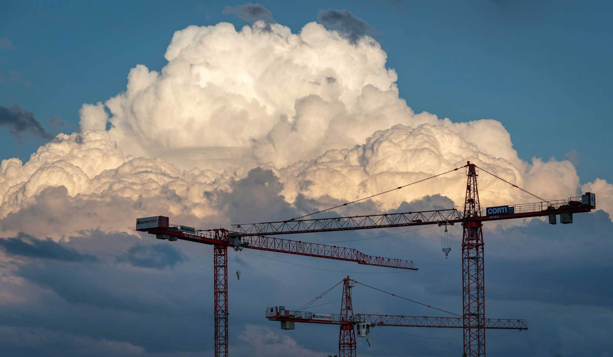 construction cranes under clouds