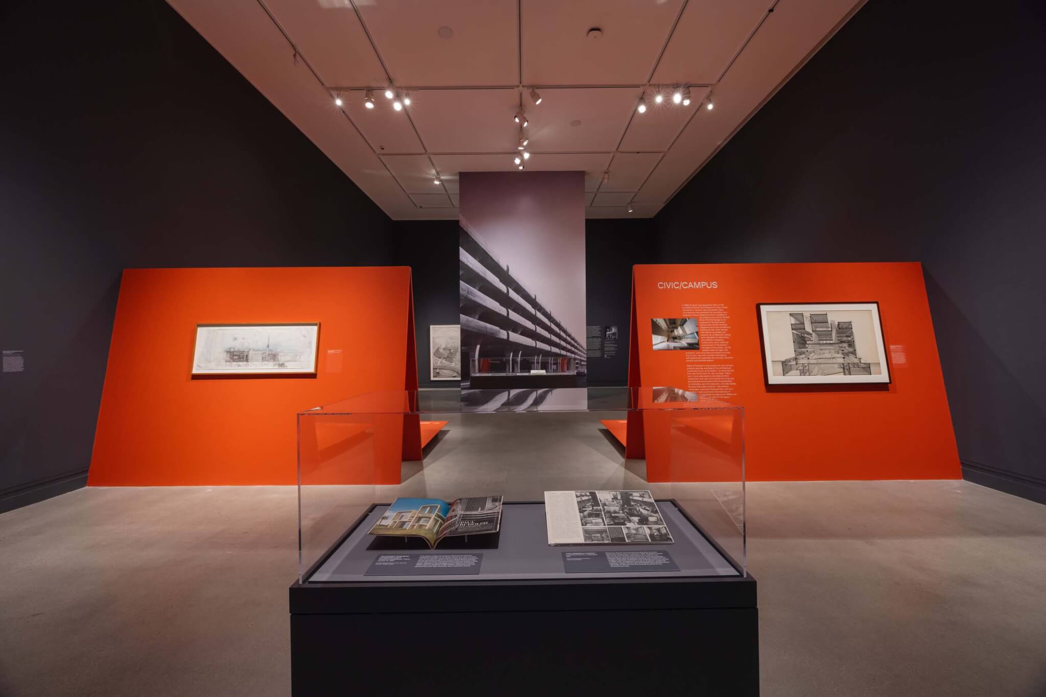 books laid out inside glass display case and text and images on walls