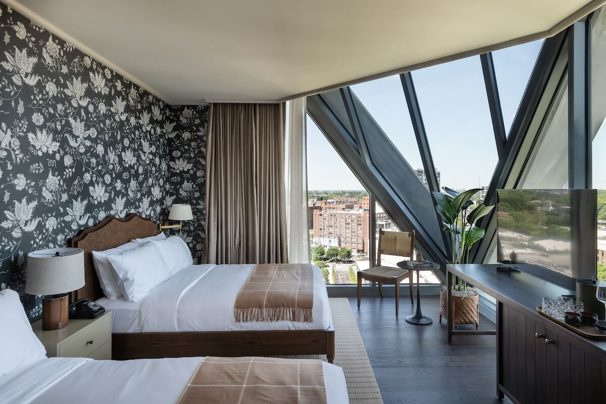 guest room inside hotel with large angular window 