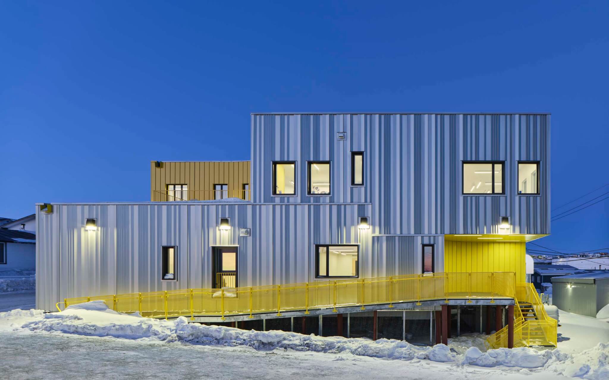 the exterior of the building by Lateral Office has a yellow staircase