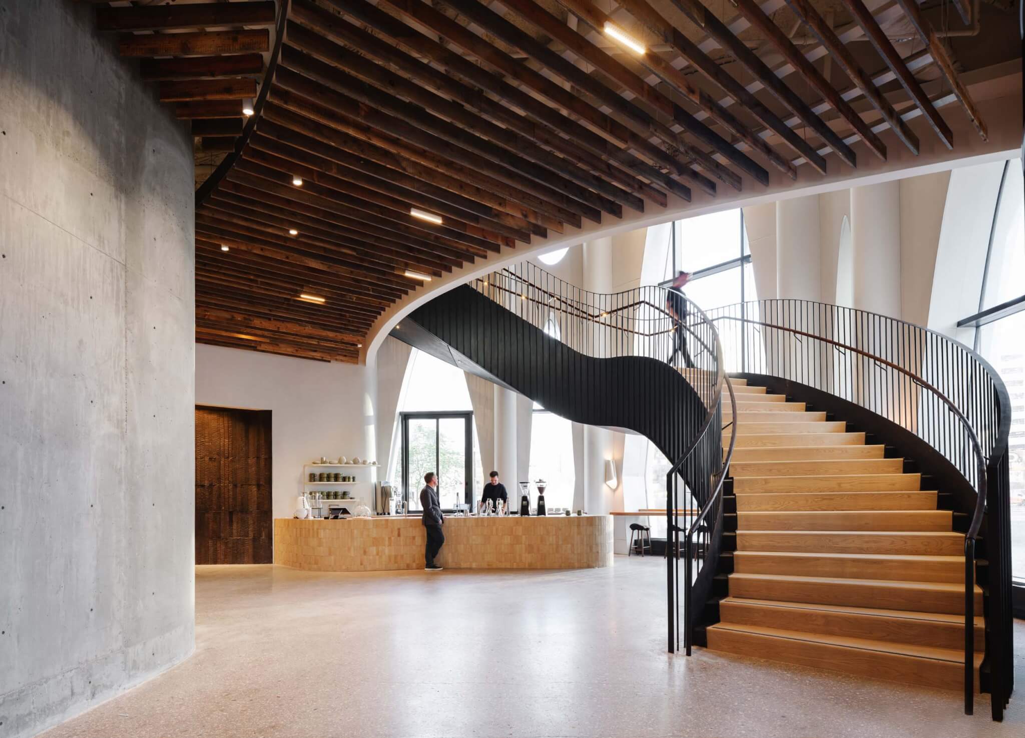 the lobby inside populus hotel with a curving wood staircase