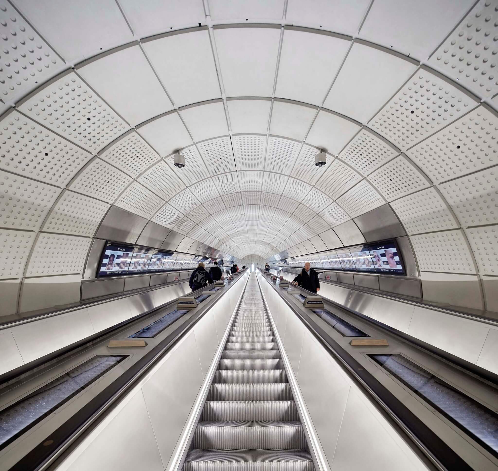 escalators with curved, decorative white ceiling of the Elizabeth Line, the Stirling Prize 2024 recipient