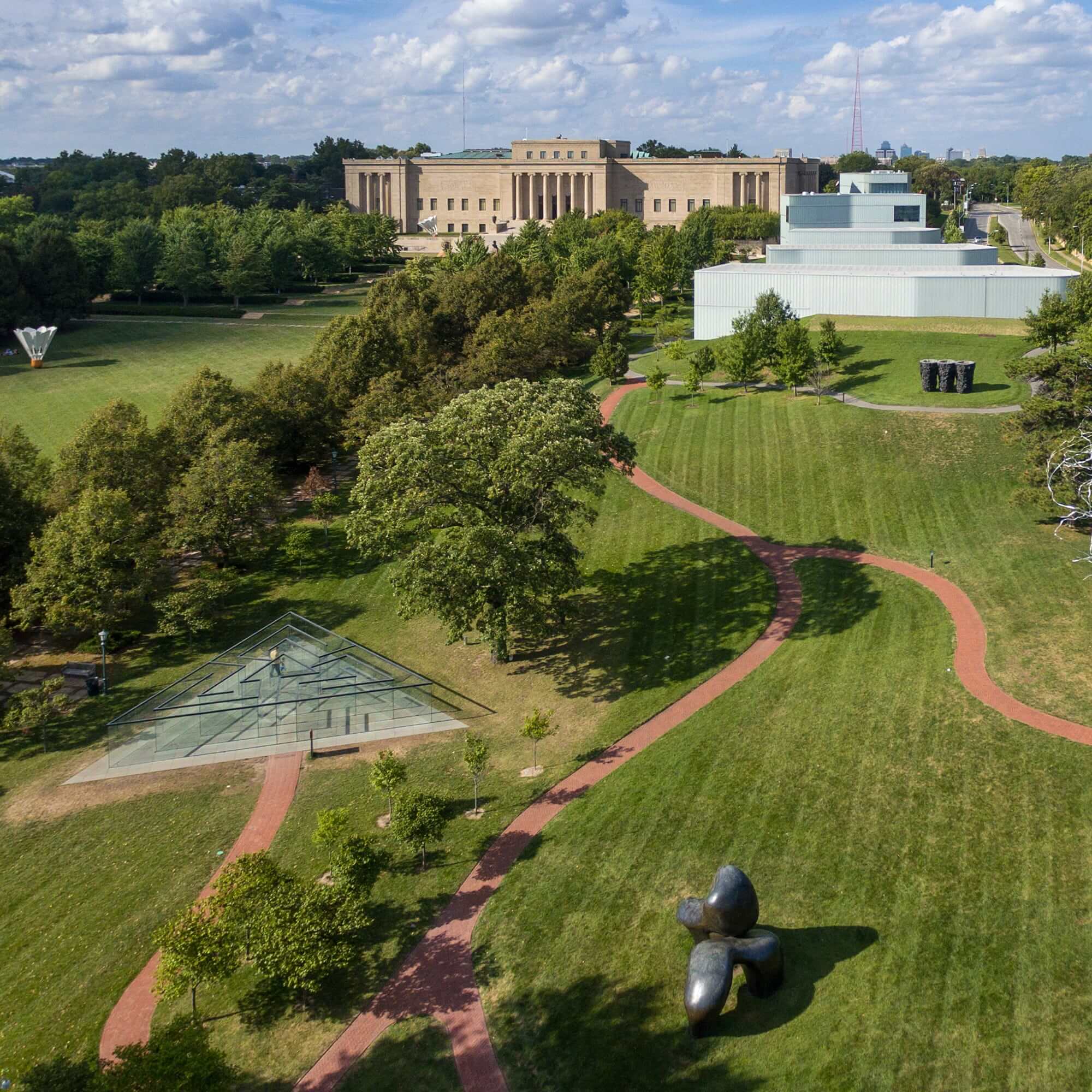 drone view of landscape with pathways and glass structure